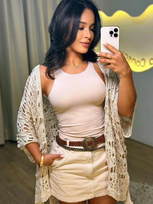 Mulher usando a Blusa Aurora bege combinada com short saia claro, em look casual sofisticado.