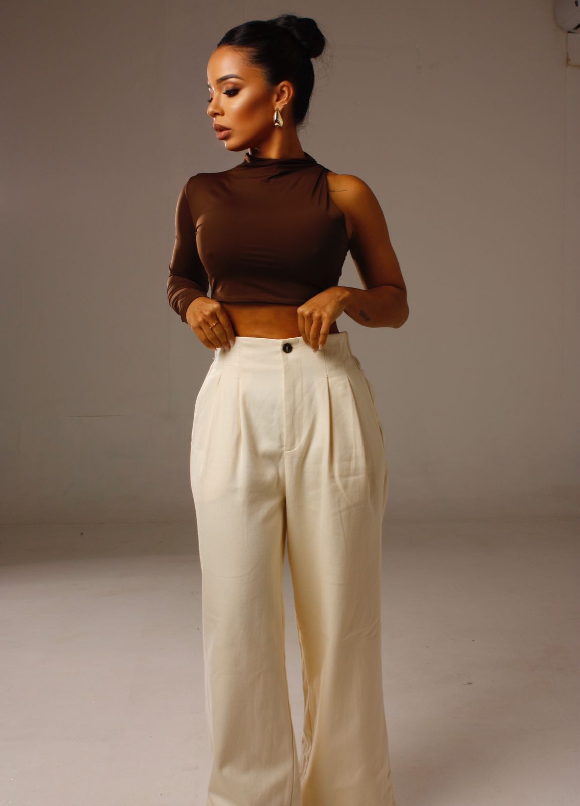 Cropped Luna 1 Ombro Só marrom em look feminino moderno com calça clara.