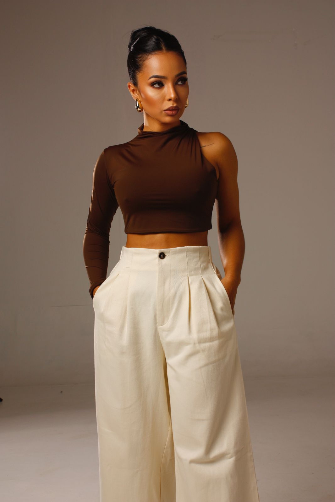Cropped Luna 1 Ombro Só marrom em look feminino moderno com calça clara.
