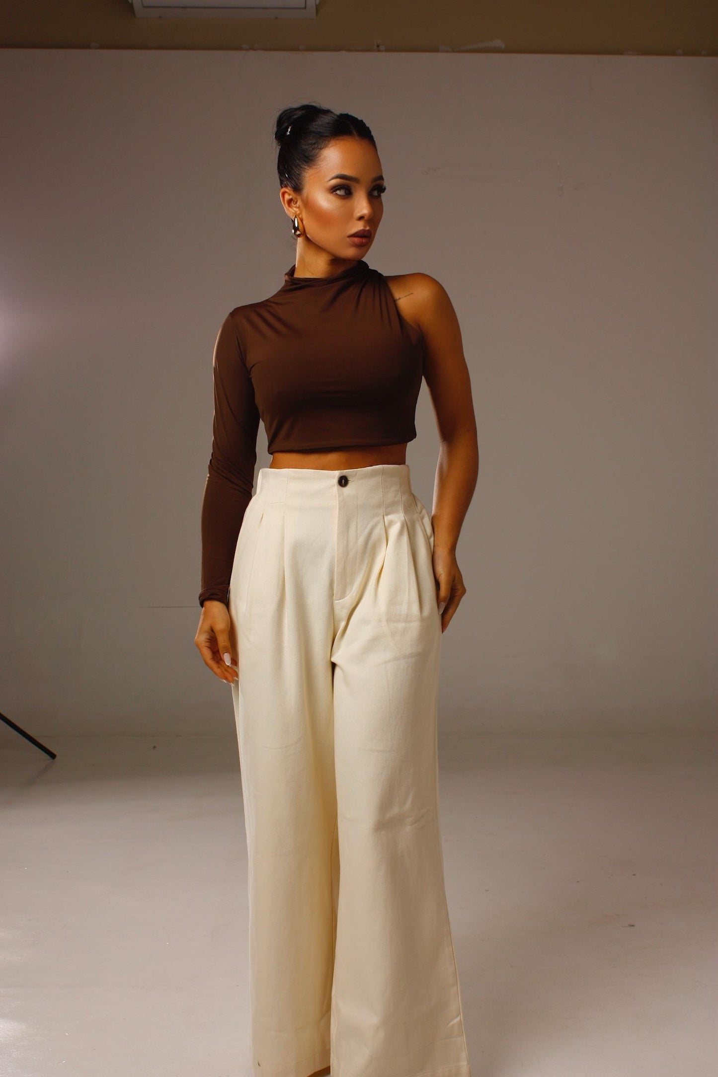 Cropped Luna 1 Ombro Só marrom em look feminino moderno com calça clara.